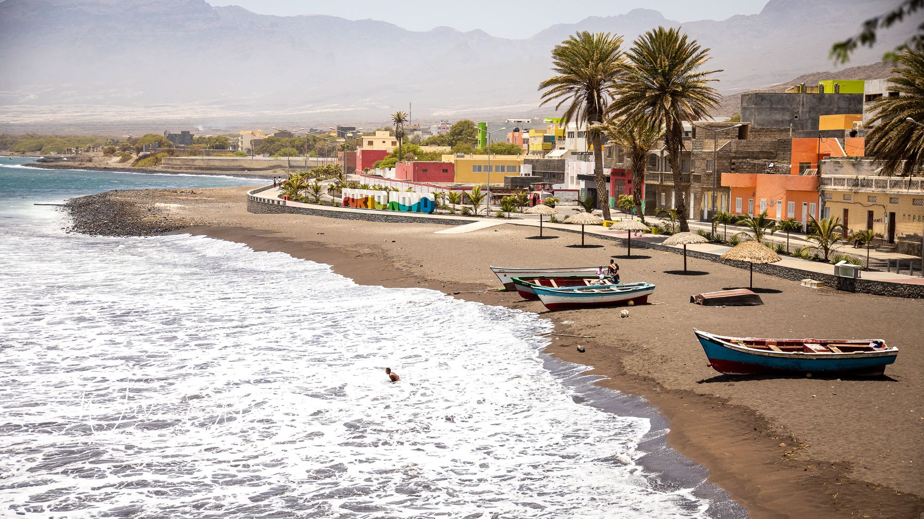 Praia d’Armazém, plage de sable noir, barques de pêche, enseigne Porto Novo colorée