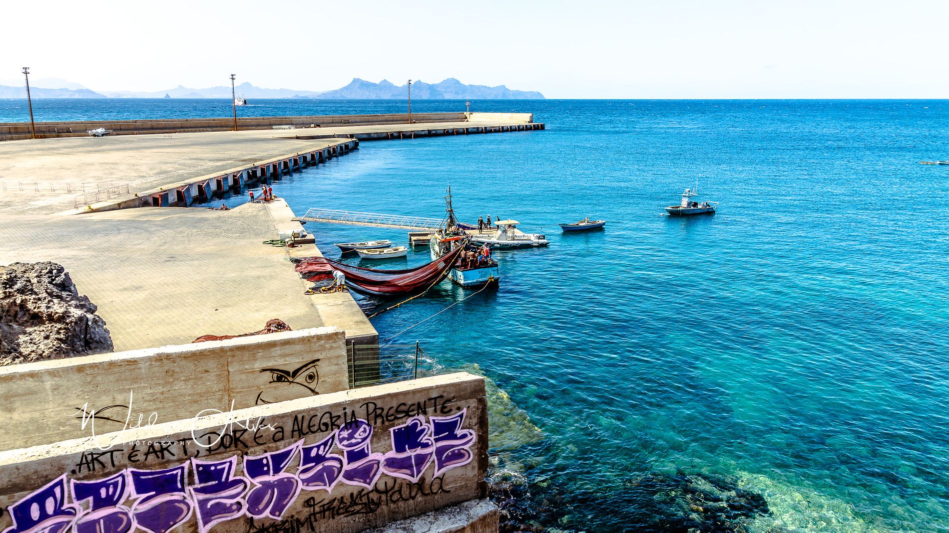 Môle du port avec graffiti et bateaux de pêche colorés à l’ancre