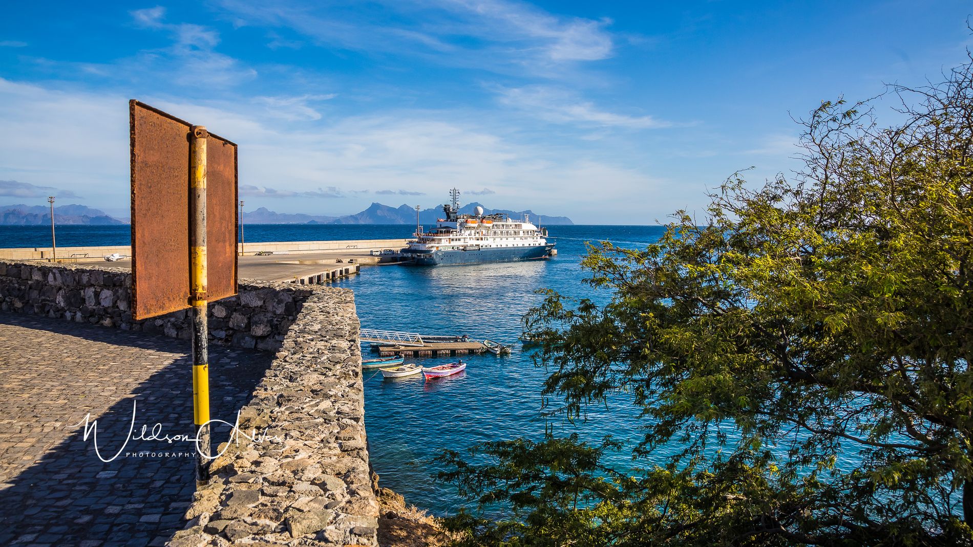 Paquebot d’expédition amarré au port, montagnes en arrière-plan